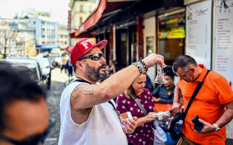 Man showcasing local snacks during a Montmartre food tour in Paris.