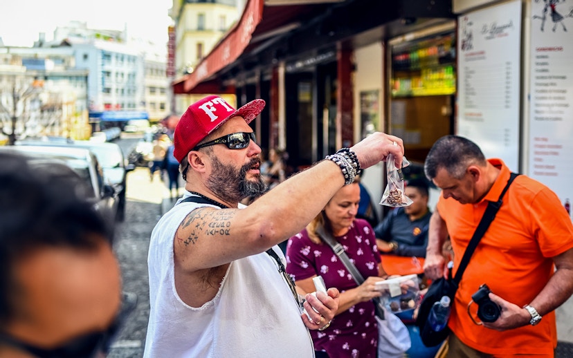 Man showcasing local snacks during a Montmartre food tour in Paris.