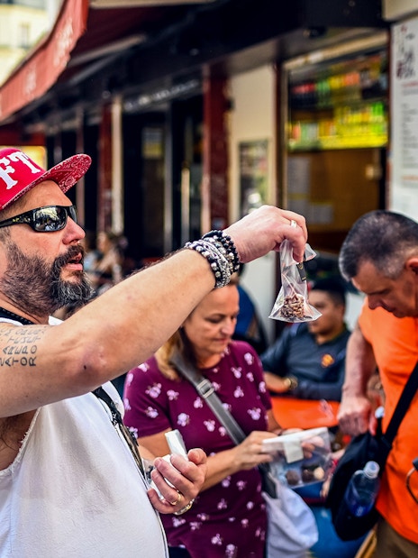 Man showcasing local snacks during a Montmartre food tour in Paris.