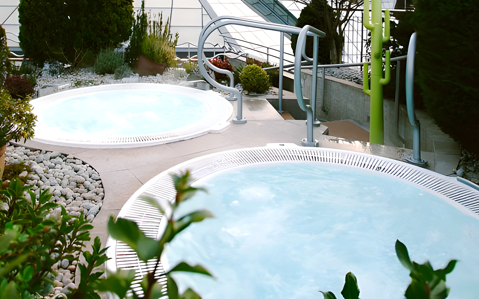 Solarium with jacuzzi at Caldea Spa, Andorra, featuring panoramic mountain views.