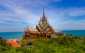 Sanctuary of Truth by the sea in Pattaya, showcasing intricate wooden architecture.