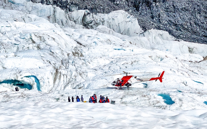 Helicopter and tourists on Fox Glacier, New Zealand.