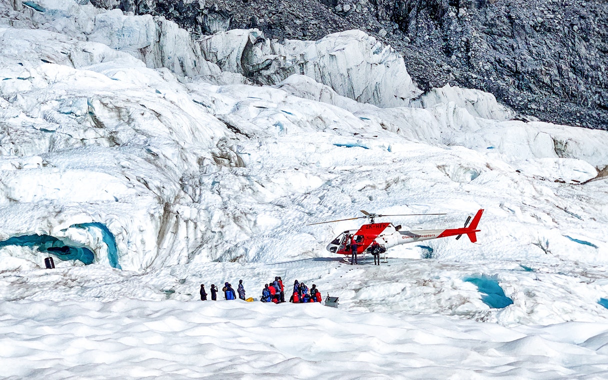 Helicopter and tourists on Fox Glacier, New Zealand.