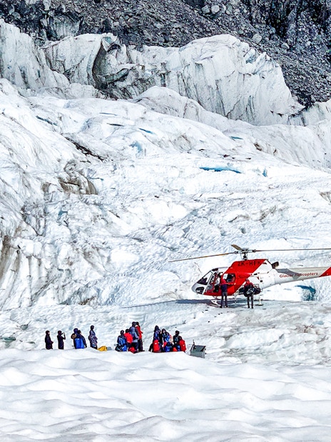 Helicopter and tourists on Fox Glacier, New Zealand.