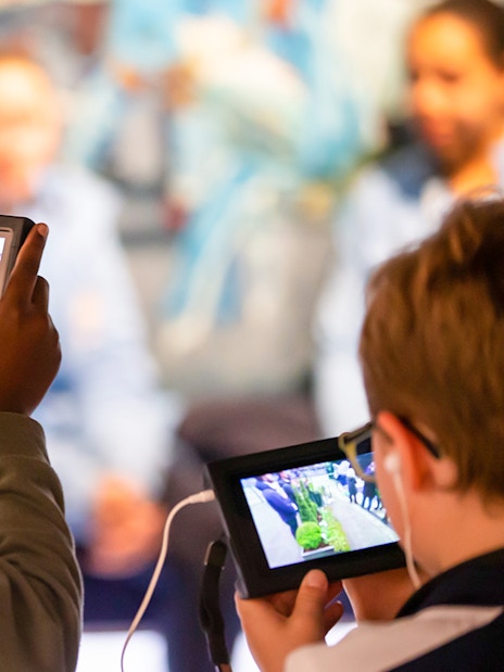 Visitors using tablets during Manchester City Stadium tour.