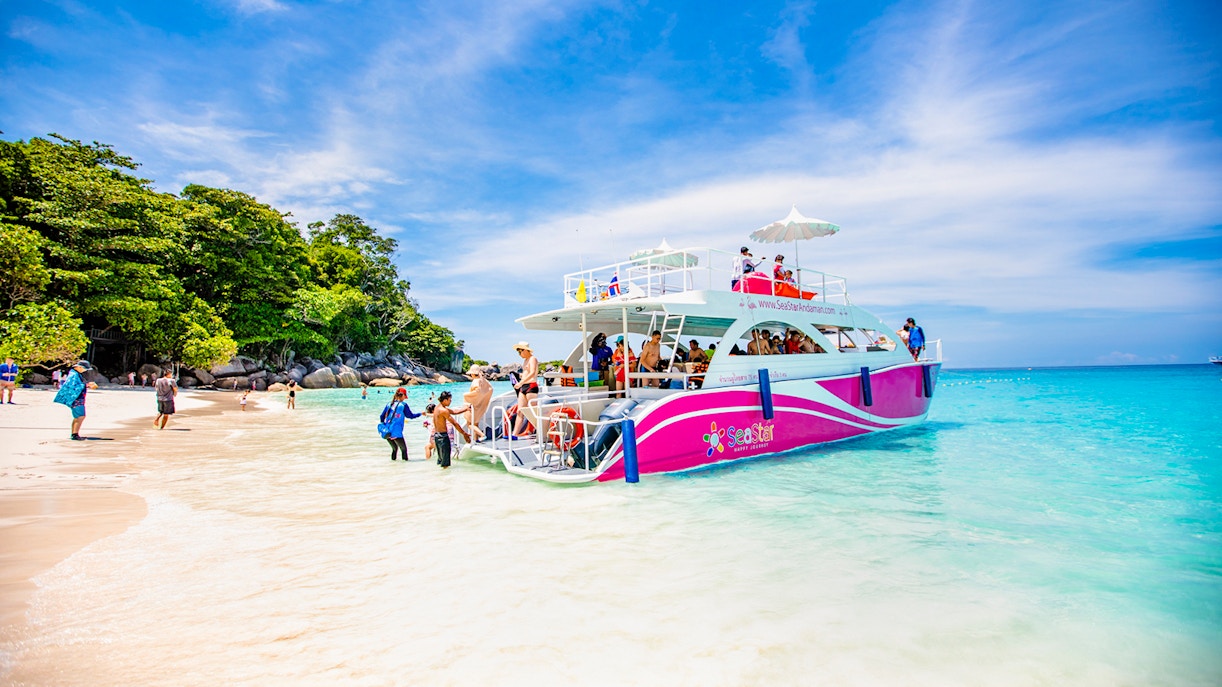 Catamaran docked at Similan Island beach with tourists boarding.