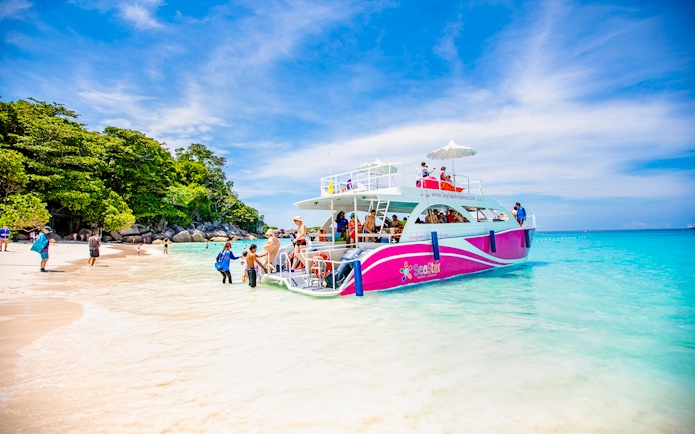 Catamaran docked at Similan Island beach with tourists boarding.