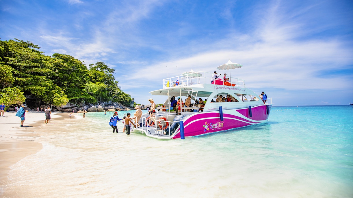 Catamaran docked at Similan Island beach with tourists boarding.