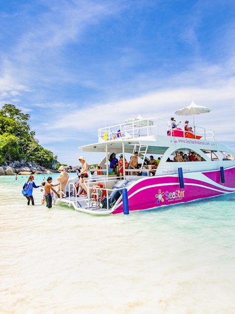 Catamaran docked at Similan Island beach with tourists boarding.