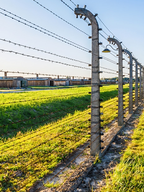Barbed wire fence and watchtower at Auschwitz Birkenau, Auschwitz II barracks in Poland.
