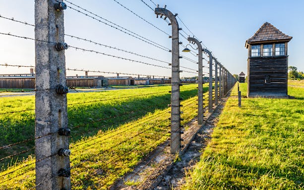 Barbed wire fence and watchtower at Auschwitz Birkenau, Auschwitz II barracks in Poland.