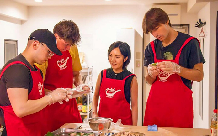 Participants in a Tokyo izakaya-style cooking class preparing ingredients together.