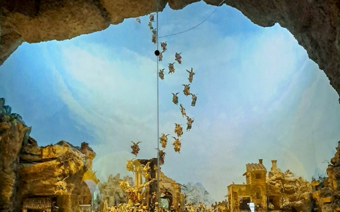 Nativity scene with angels above a village, part of Castel Sant'Elmo and Certosa di San Martino tour in Naples.