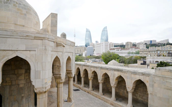 Old city architecture with modern Flame Towers in Baku, Azerbaijan.