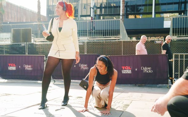Guests exploring Hollywood Walk of Fame with TCL Chinese Theatre in background.