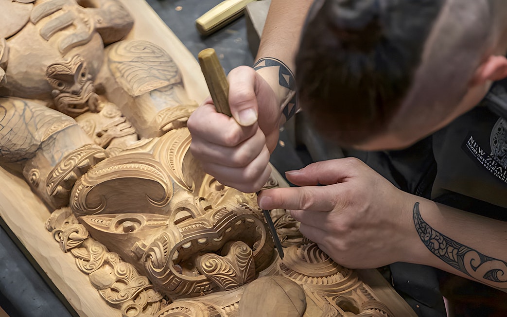 Carving traditional Maori wood sculpture at Te Puia cultural site, Rotorua.