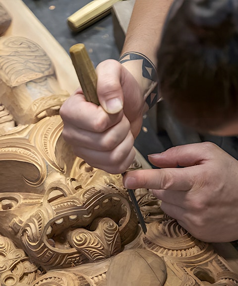 Carving traditional Maori wood sculpture at Te Puia cultural site, Rotorua.