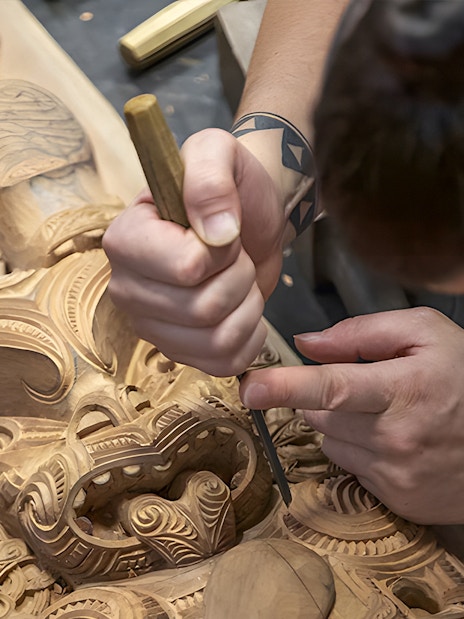 Carving traditional Maori wood sculpture at Te Puia cultural site, Rotorua.