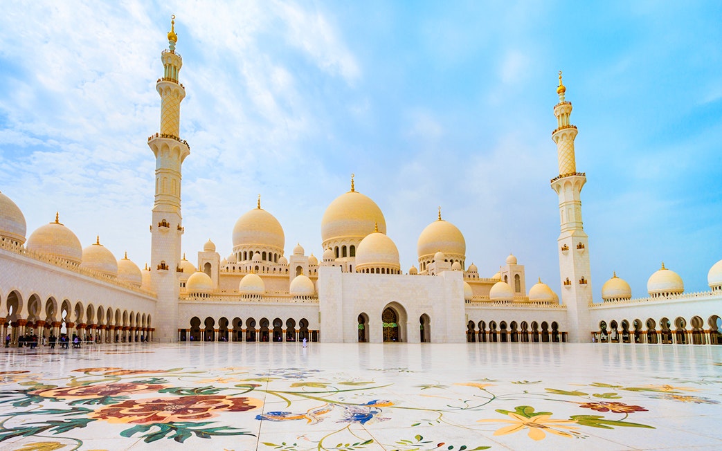 Sheikh Zayed Grand Mosque courtyard in Abu Dhabi with floral marble design.