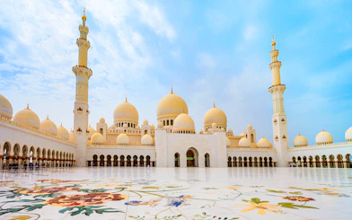 Sheikh Zayed Grand Mosque courtyard in Abu Dhabi with floral marble design.