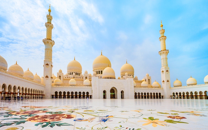 Sheikh Zayed Grand Mosque courtyard in Abu Dhabi with floral marble design.