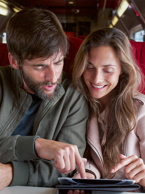 Couple using an iPad on an Interrail train journey.
