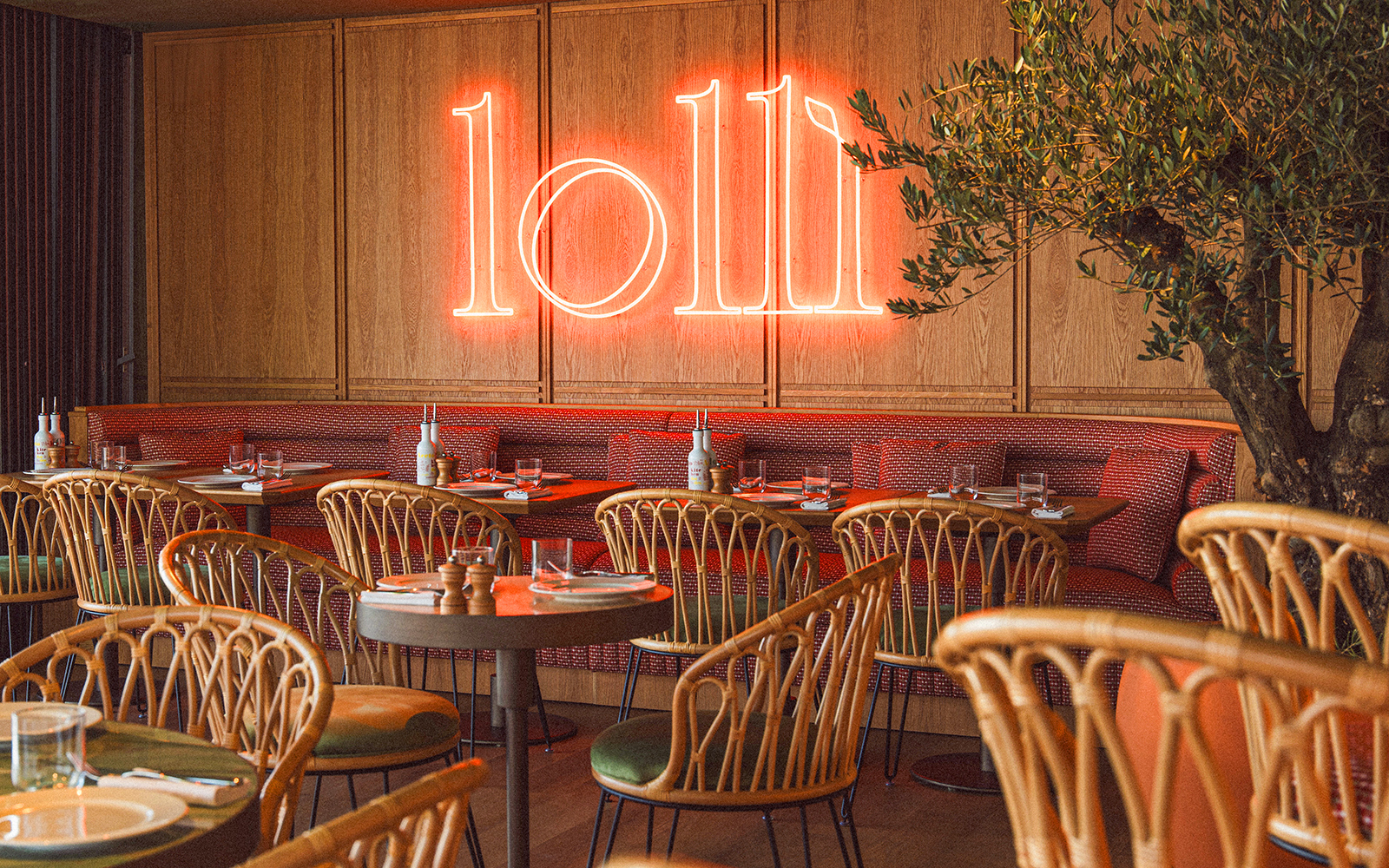 Restaurant interior with neon sign and set tables for lunch.