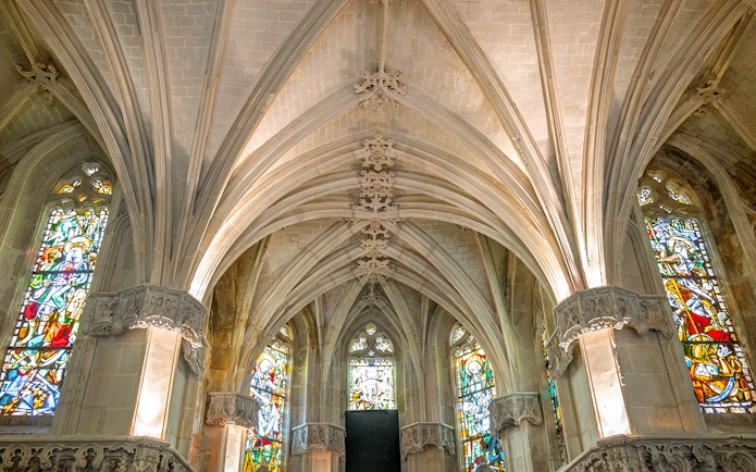 Royal Amboise Castle chapel interior with stained glass windows and vaulted ceiling.
