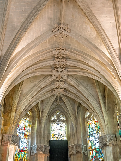 Royal Amboise Castle chapel interior with stained glass windows and vaulted ceiling.