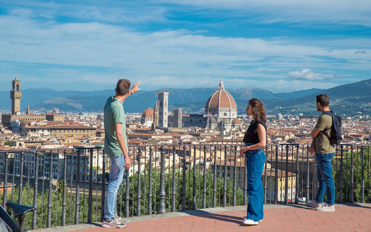 Tourists enjoying the view of Florence from Piazzale Michelangelo with the Duomo in the background.