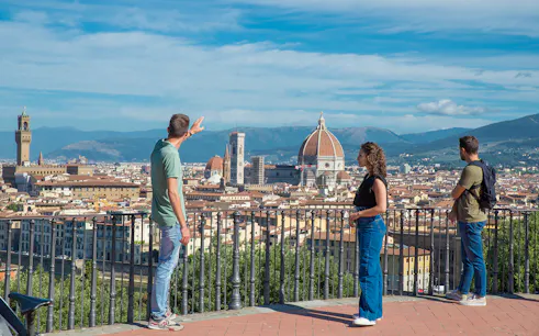 Tourists enjoying the view of Florence from Piazzale Michelangelo with the Duomo in the background.