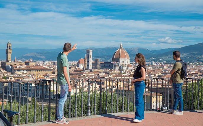 Tourists enjoying the view of Florence from Piazzale Michelangelo with the Duomo in the background.