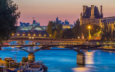 Pont des Arts bridge over the Seine River at sunset in Paris.
