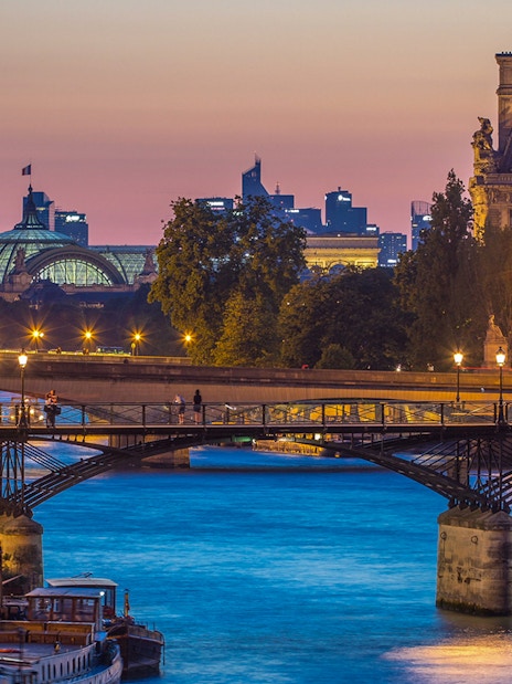 Pont des Arts bridge over the Seine River at sunset in Paris.