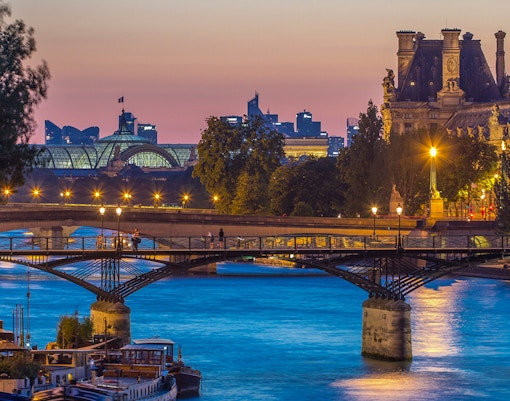 Pont des Arts bridge over the Seine River at sunset in Paris.