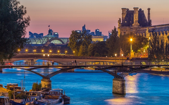 Pont des Arts bridge over the Seine River at sunset in Paris.