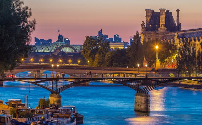 Pont des Arts bridge over the Seine River at sunset in Paris.