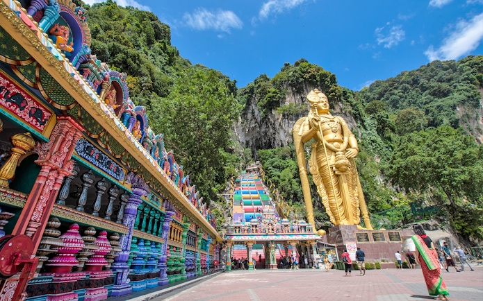 Murugan statue and colorful temple entrance at Batu Caves, Kuala Lumpur.