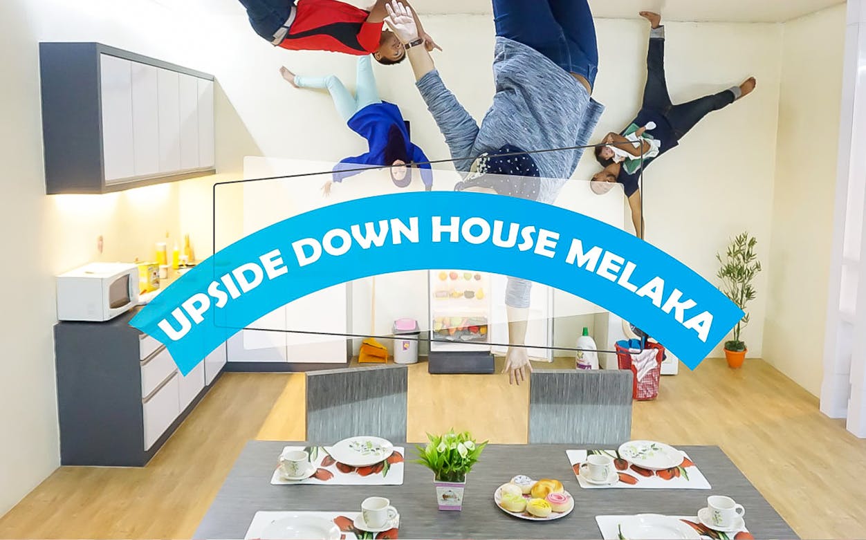 Visitors appear upside down in a kitchen at Upside Down House Melaka.