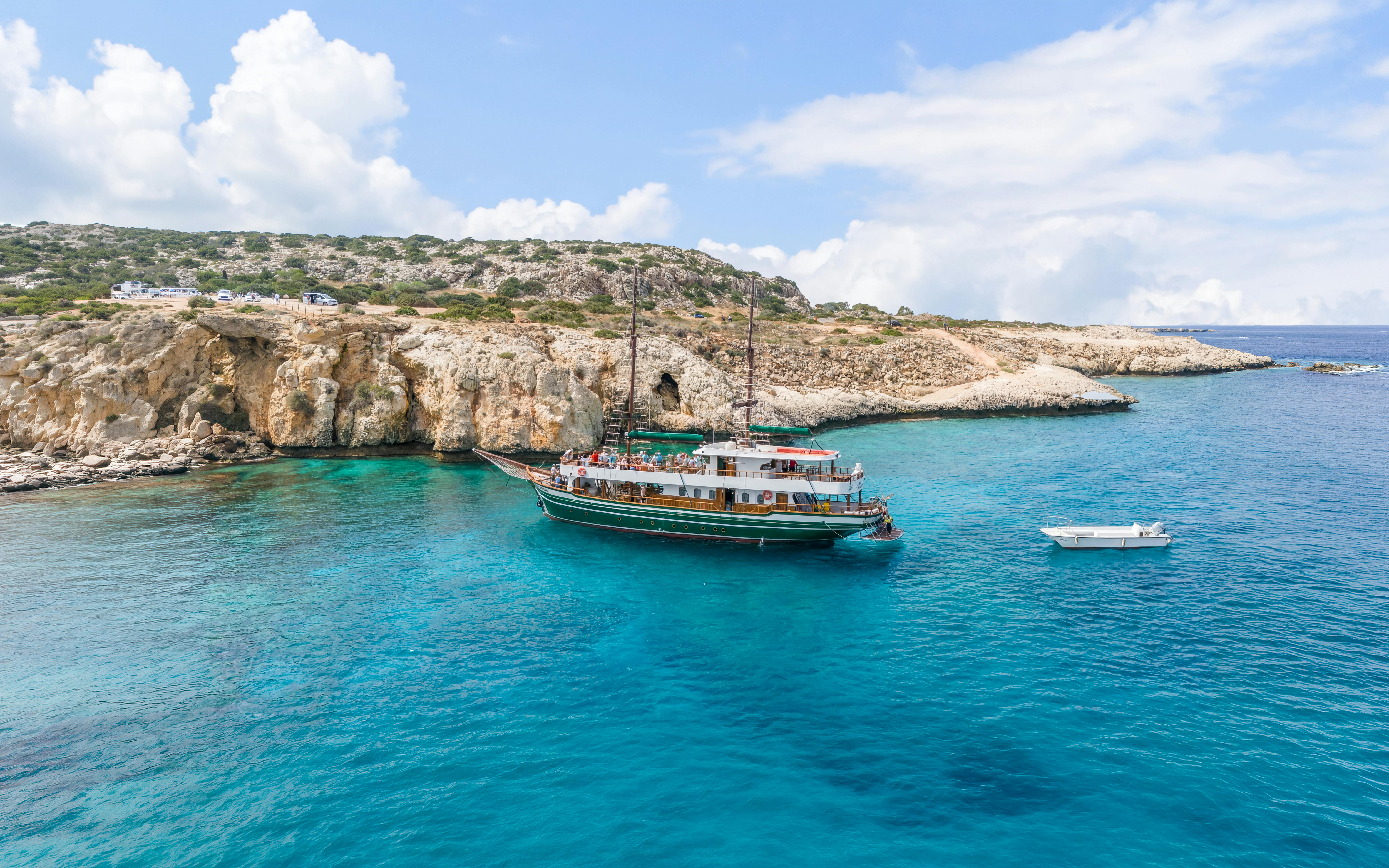 Boat near rocky cliffs in Blue Lagoon, Protaras, Cyprus.