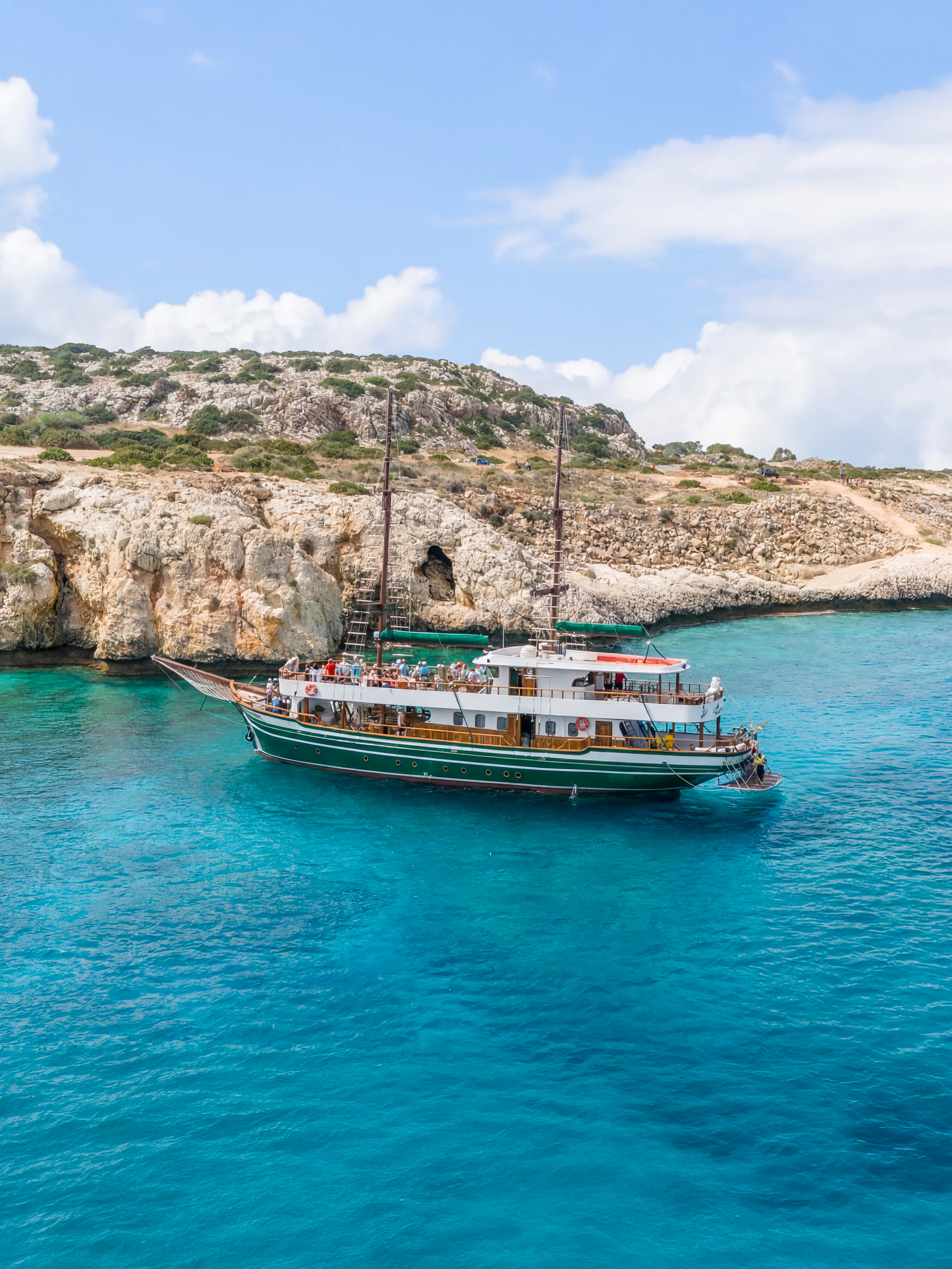 Boat near rocky cliffs in Blue Lagoon, Protaras, Cyprus.