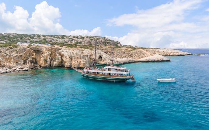 Boat near rocky cliffs in Blue Lagoon, Protaras, Cyprus.