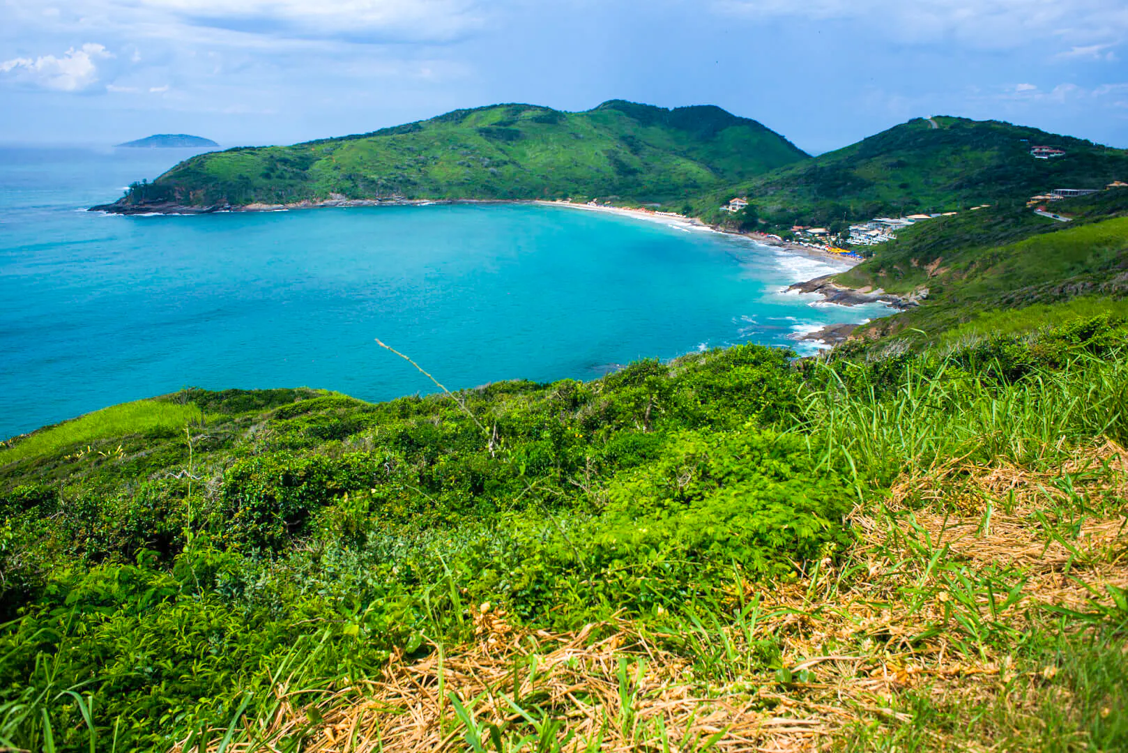 Coastal view of José Gonçalves beach in Búzios, Rio de Janeiro, surrounded by lush green hills.