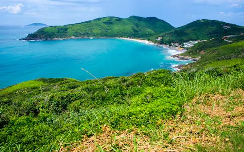 Coastal view of José Gonçalves beach in Búzios, Rio de Janeiro, surrounded by lush green hills.