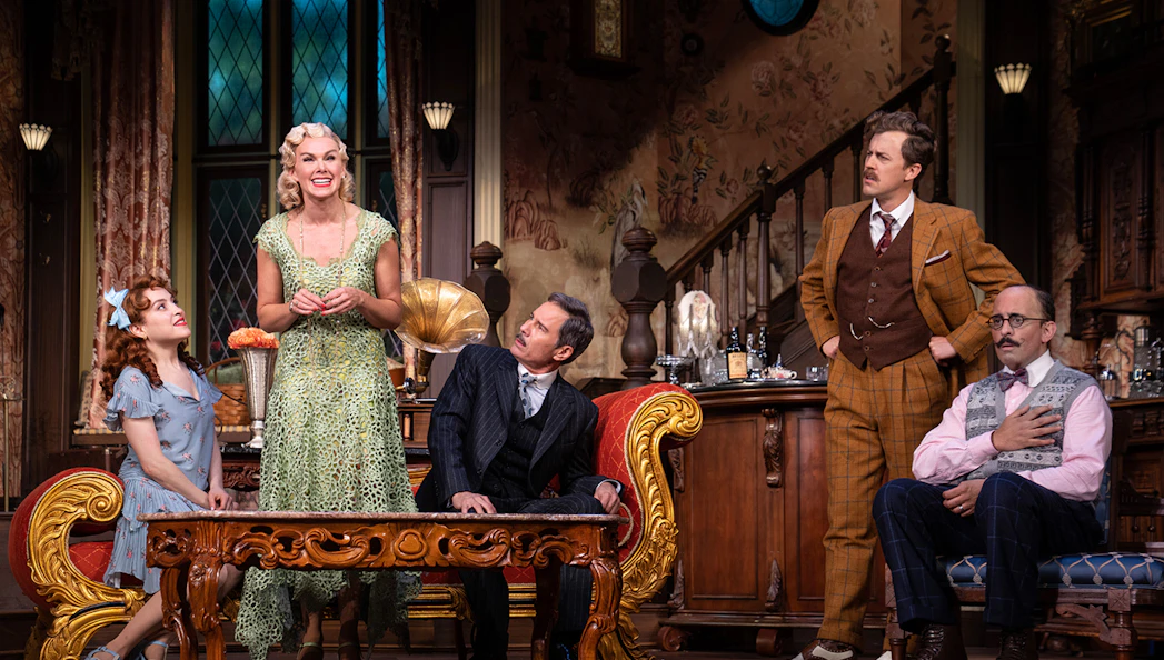 Actors performing a scene in a vintage living room setting for "The Cottage" play.