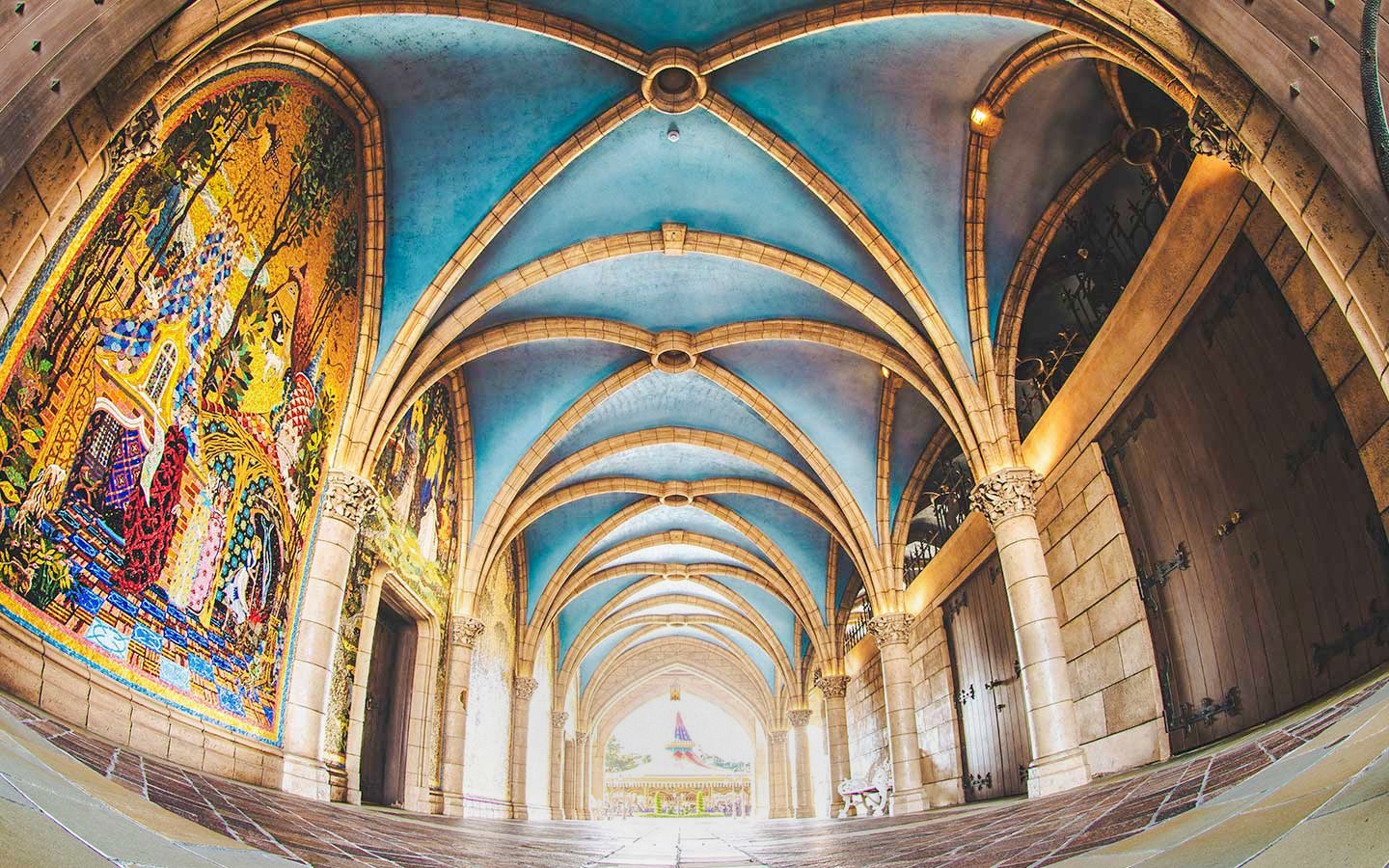 Tokyo Disneyland archway with colorful mosaic and vaulted ceiling.
