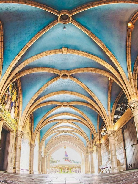 Tokyo Disneyland archway with colorful mosaic and vaulted ceiling.