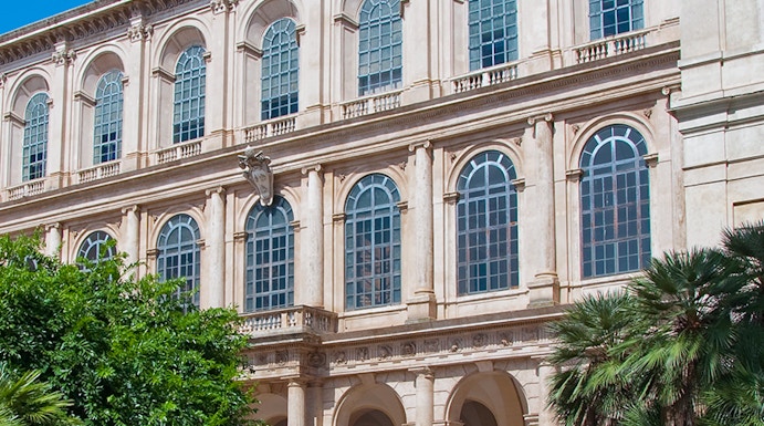 Galleria Corsini facade with arched windows and lush greenery in Rome, Italy.