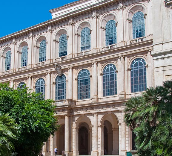 Galleria Corsini facade with arched windows and lush greenery in Rome, Italy.