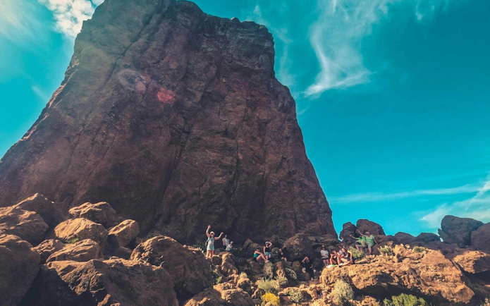 Hikers exploring rocky terrain during Gran Canaria volcano sunset tour.